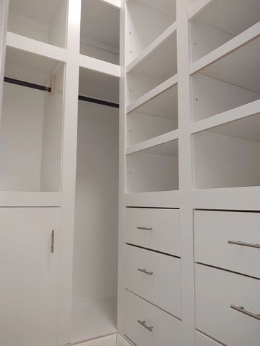 Custom design and built master bedroom walk in closet with doors and drawers. 