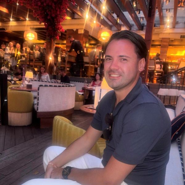 Man sitting and smiling in a cozy restaurant.