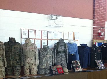 Display of various military uniforms from different branches and eras on mannequins.