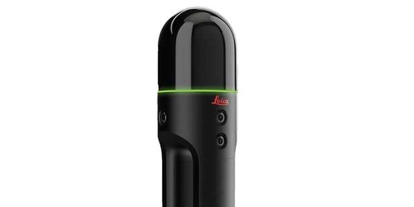 A sleek black Leica scanning device with a glowing green ring under a glossy top.