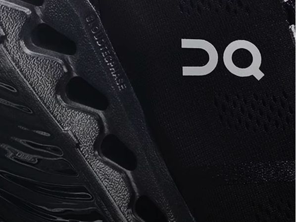 Close-up of a black sports shoe with a textured sole and logo.