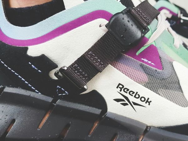 Close-up of a colorful Reebok sneaker with strap detail.