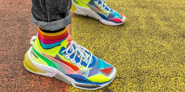 Person wearing colorful sneakers and striped socks.