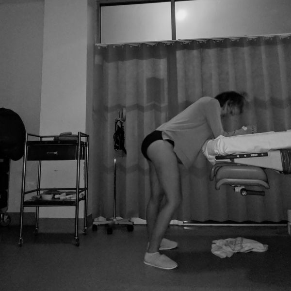 Person leaning over a table in a dimly lit room.