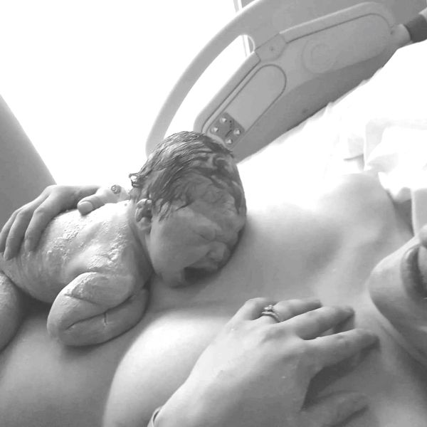 Newborn baby resting on mother's chest after birth.