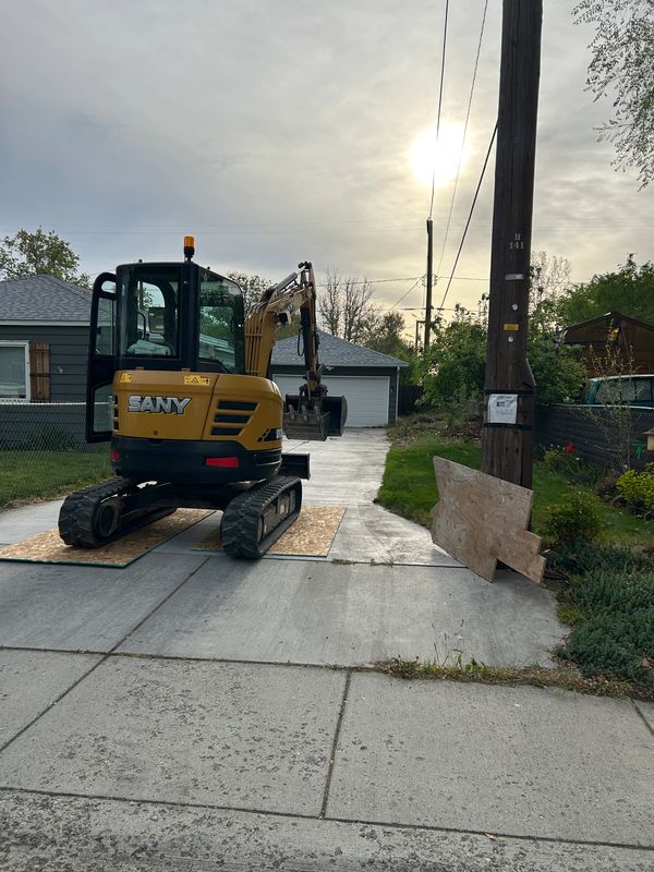 Yellow SANY excavator on driveway.