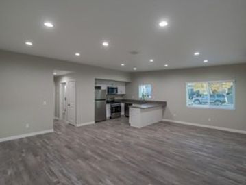 Modern kitchen with open floor plan and grey flooring.