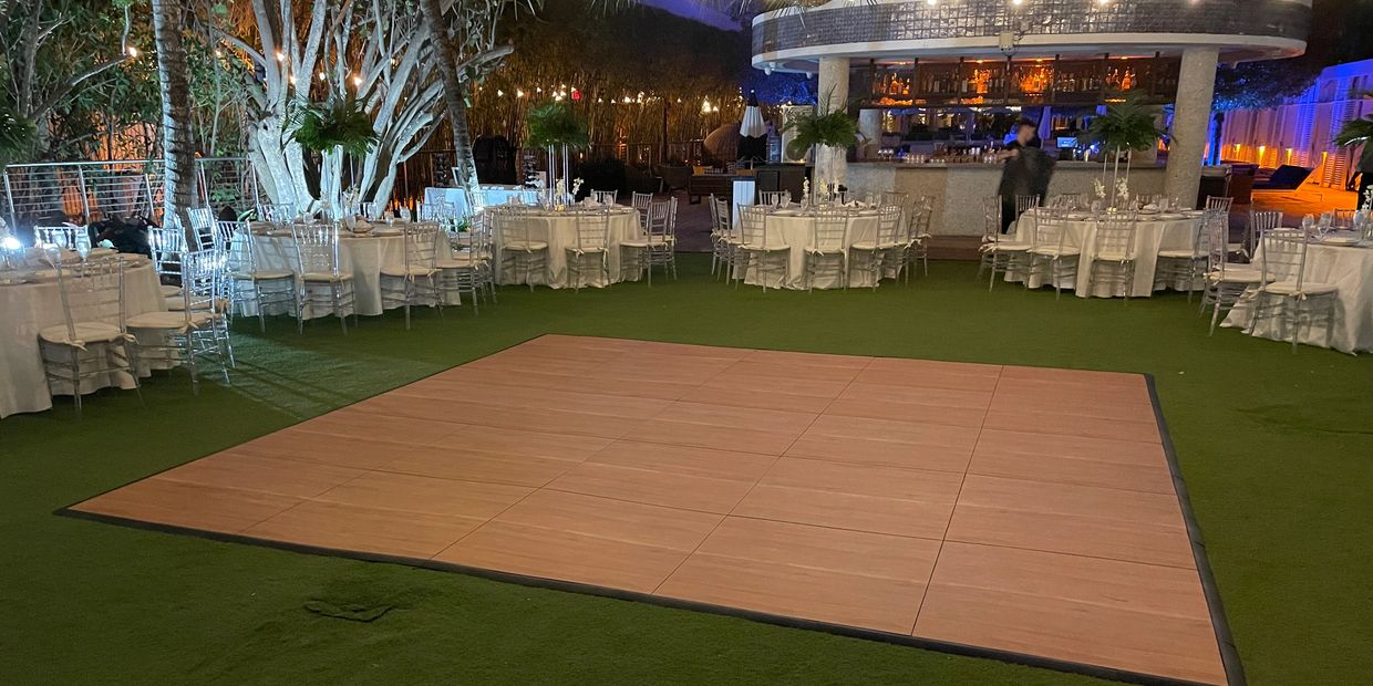 big portable dance floor on grass carpet in hotel patio 