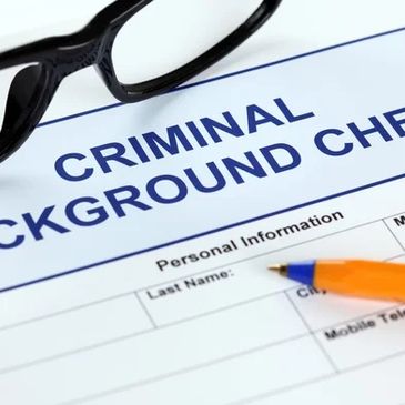 Criminal background check form with glasses and pen on it.
