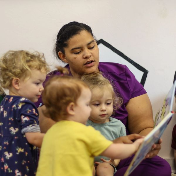 An educator reads a children's story to toddlers. Childcare in Tallahassee.