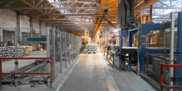Industrial factory interior with machinery and stacked materials.
