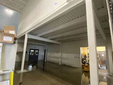 Empty industrial space with concrete floor and metal beams.
