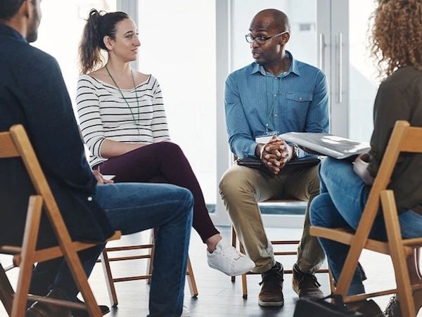 A diverse group having a discussion in a casual meeting setting.