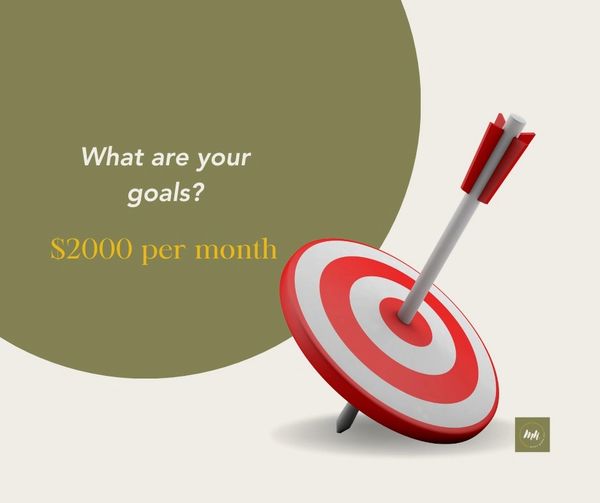 A dart hits the bullseye with the goal of earning $2000 per month.