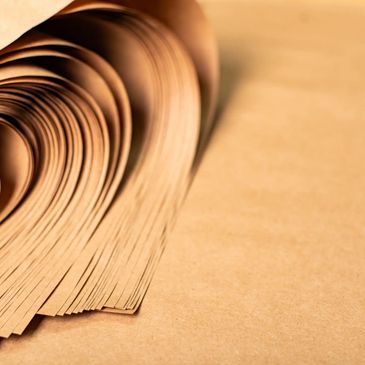 Rolled brown paper sheets arranged in a curved stack.