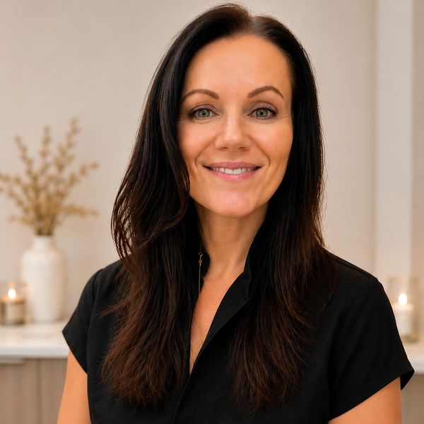 Woman with long dark hair smiling.