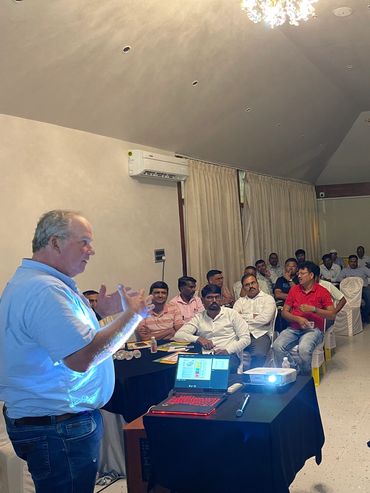 Man giving a presentation to a group of attentive people in a conference room.