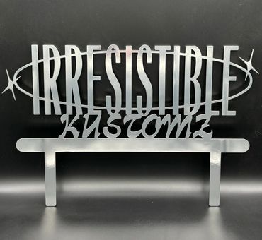 Silver metallic sign reading 'IRRESISTIBLE KUSTOMZ' with a starry oval design.