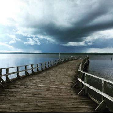 Wooden dock reaches into the waters of Lake Superior under a cloudy sky in Ashland, WI.
