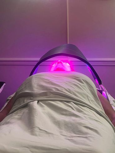 Person undergoing facial treatment with LED light therapy.