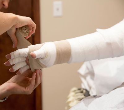 Therapist applying compression bandaging for a client with lympedema in her arm.