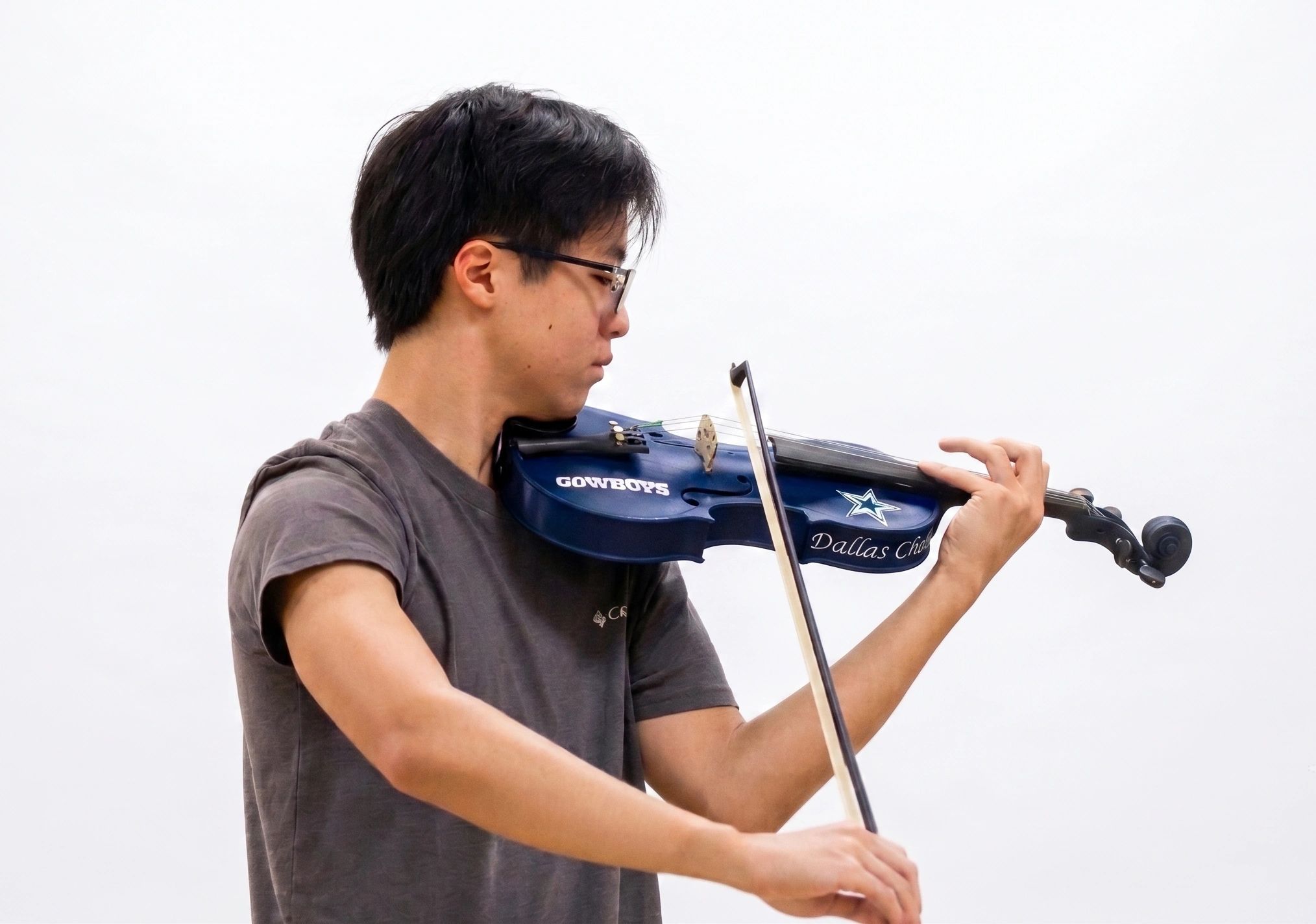 Person playing a blue Dallas Cowboys 3d-printed violin.
