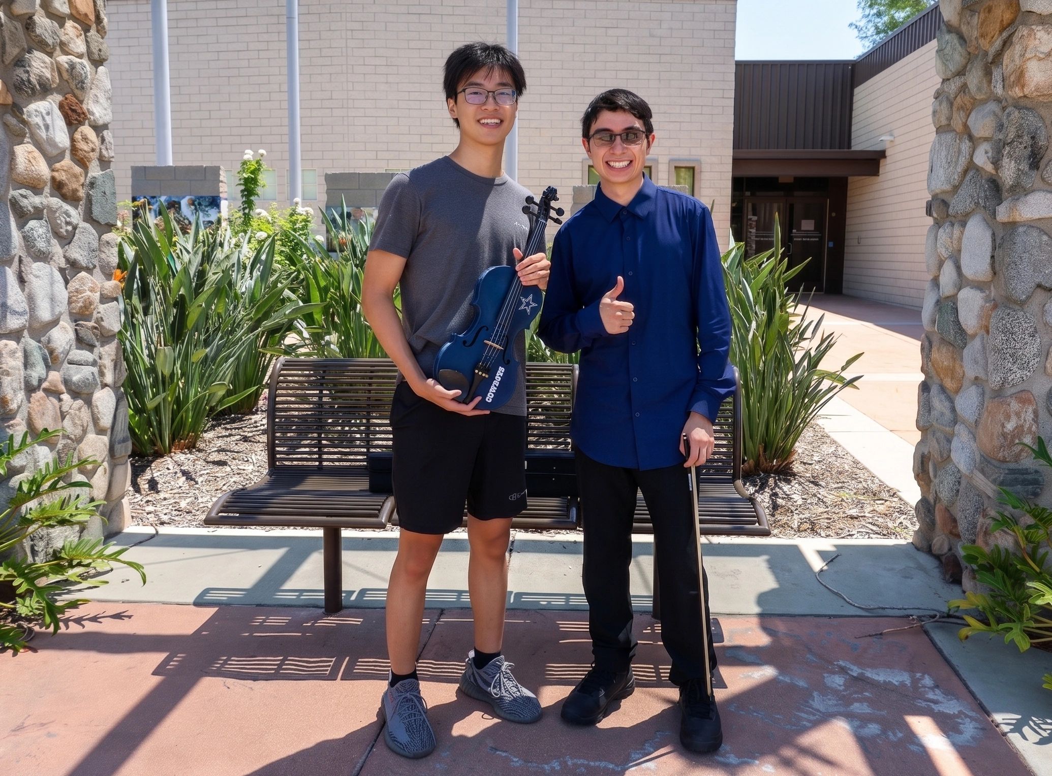 Two smiling men posing outside with a 3D printed violin.