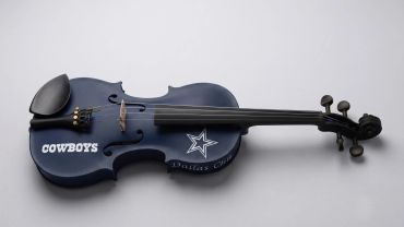 A Dallas Cowboys-themed violin on a white surface.