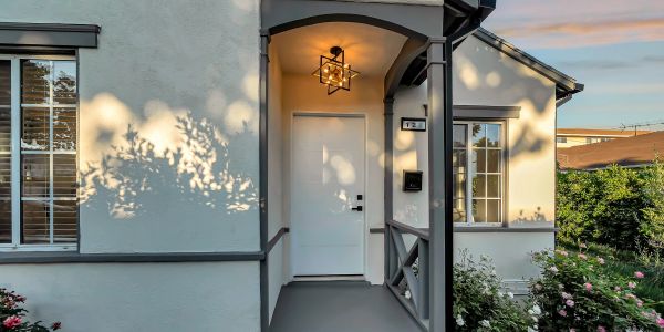 Front porch of a house with soft lighting and flowers.