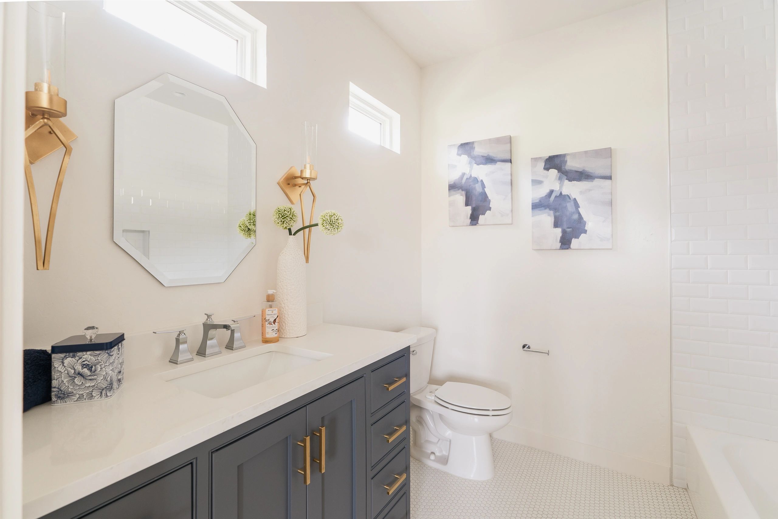 En-suite bathroom with white beveled subway tile shower and tub combination and lots of natural ligh