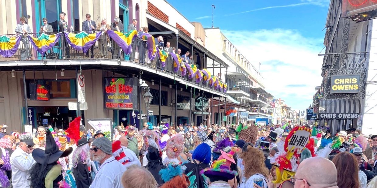 Crowd in colorful costumes at a festive street event.