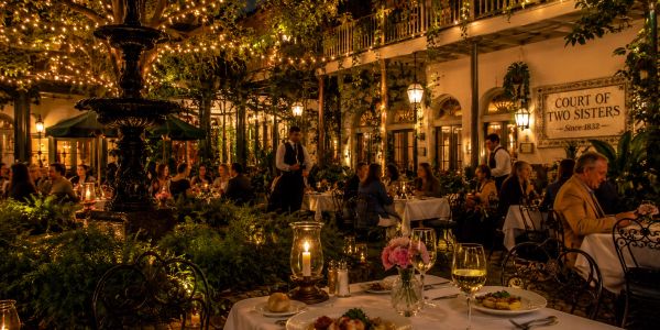 Cozy outdoor dining with string lights at Court of Two Sisters.