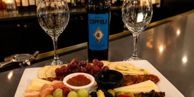 Charcuterie board with wine and glasses on a counter.