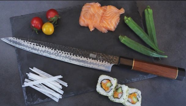 Knife with salmon, sushi, okra, cherry tomatoes, and shredded white radish.