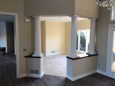 Interior view of a room with white columns and beige walls.