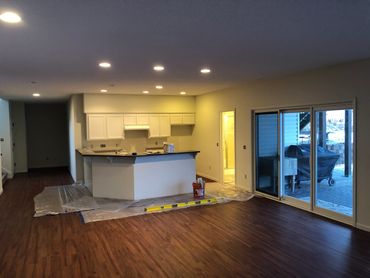 Newly renovated open kitchen with wooden floors and sliding glass doors.