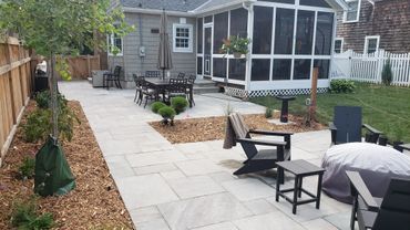Modern backyard patio with outdoor dining and seating areas.