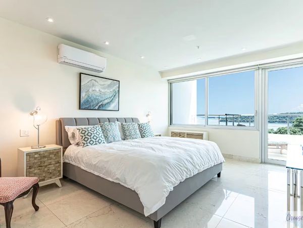 Bright modern bedroom with large window and ocean view.