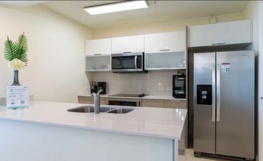 Modern kitchen with stainless steel appliances and a clean white countertop.
