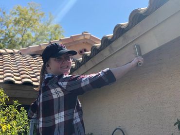 Chloe Spackman painting the facia of this rental property.