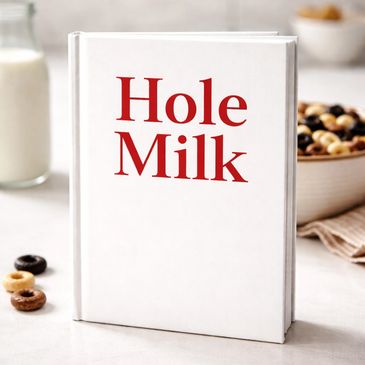 A book titled 'Hole Milk' with breakfast items in the background.