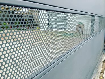 Perforated metal panel on a modern building facade.