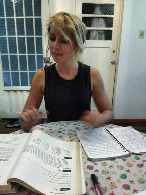 Friendly Spanish teacher leading a dynamic grammar lesson on a whiteboard.