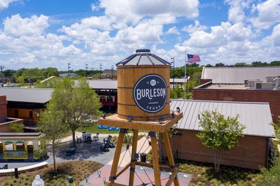 Historic Burleson water tower landmark in Texas under blue sky.