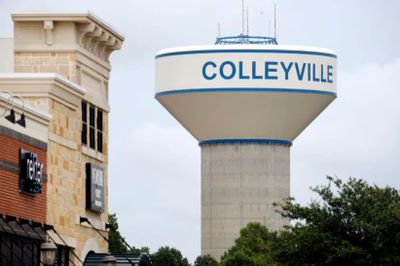 Water tower labeled Colleyville in a suburban setting.