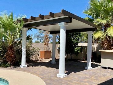 White pergola covering a spacious concrete patio.