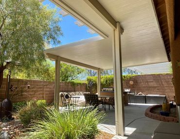 Light brown pergola over a backyard patio.