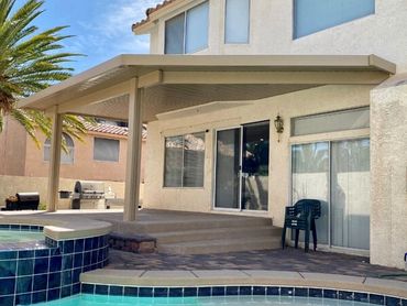 Large beige patio cover overlooking a pool.