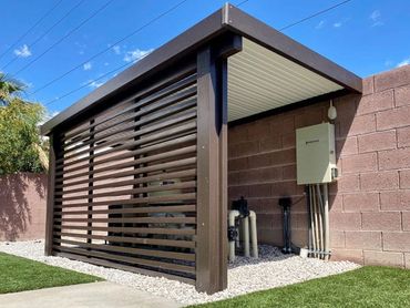 Modern black pergola with a privacy screen.