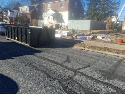 Dumpster and construction materials in a residential area.